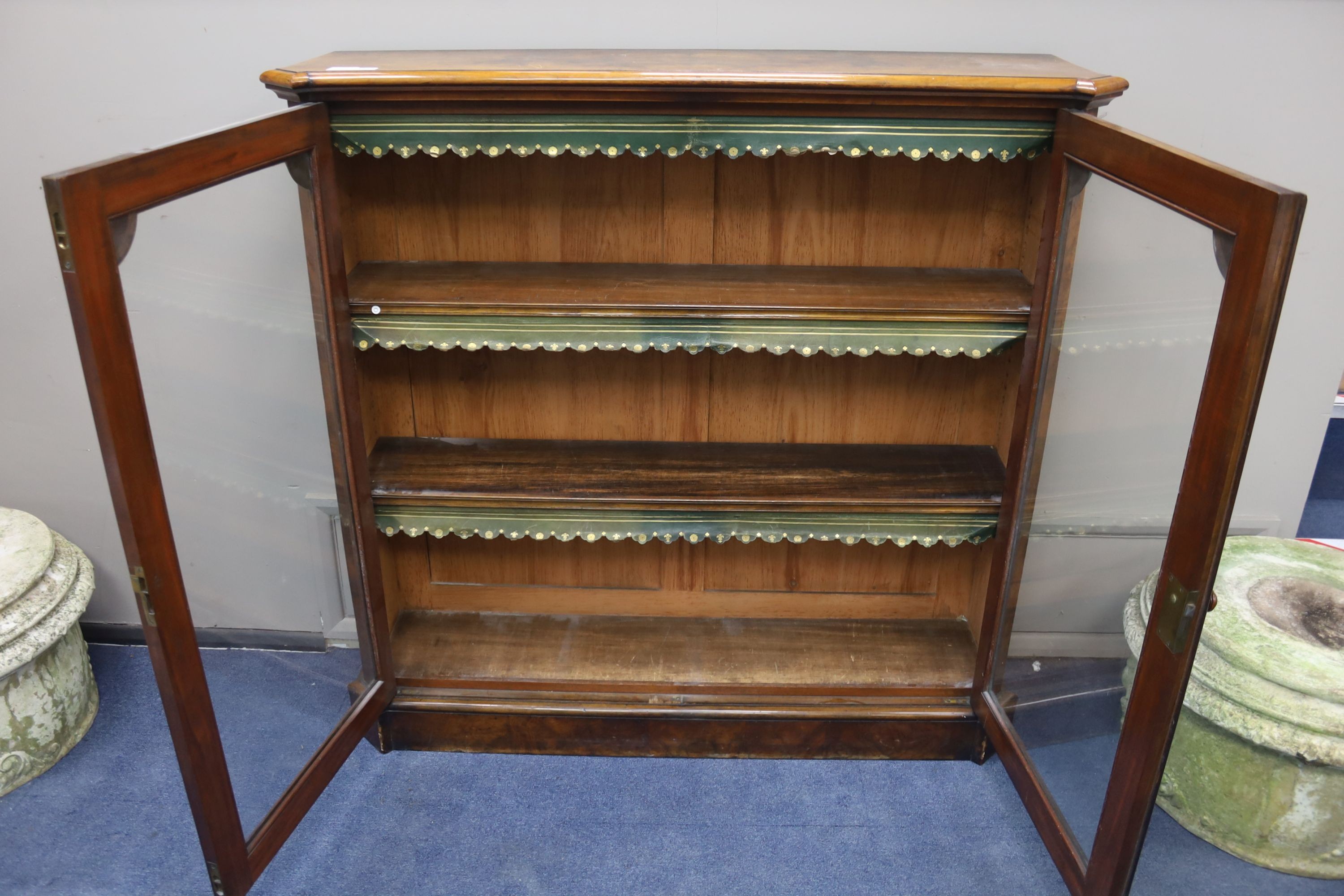 A Victorian walnut veneered bookcase with twin panelled glazed doors, length 126cm, depth 33cm, height 122cm